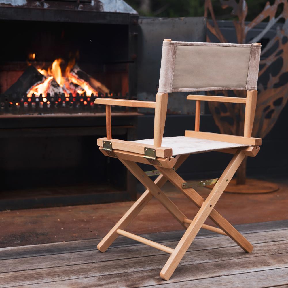 An Anifurry Beige Moab Director Chair in front of a fireplace