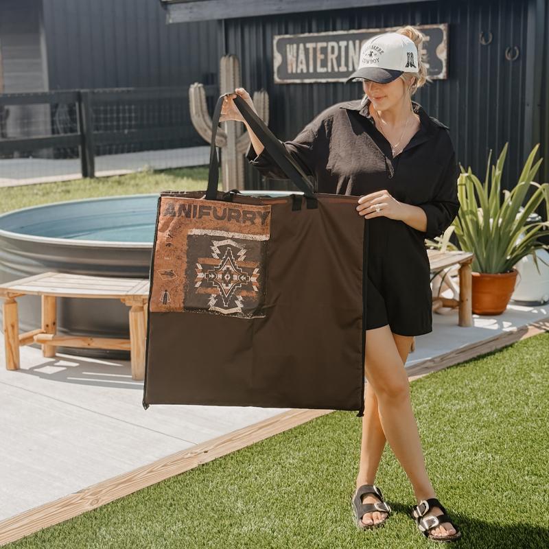 A woman holding a large brown outdoor picnic tote with an Anifurry logo in an outdoor setting