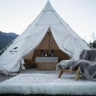 The white faux fur rug is beside a tent. The high-quality rug is reversible and suitable for camping. Easy to wash and store.