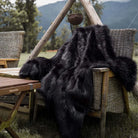 A queen size black faux fur throw blanket on the sofa. It is the softest fake fur blanket you can get.