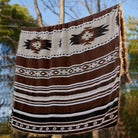 An aztec faux fur blanket hanging in the field.
