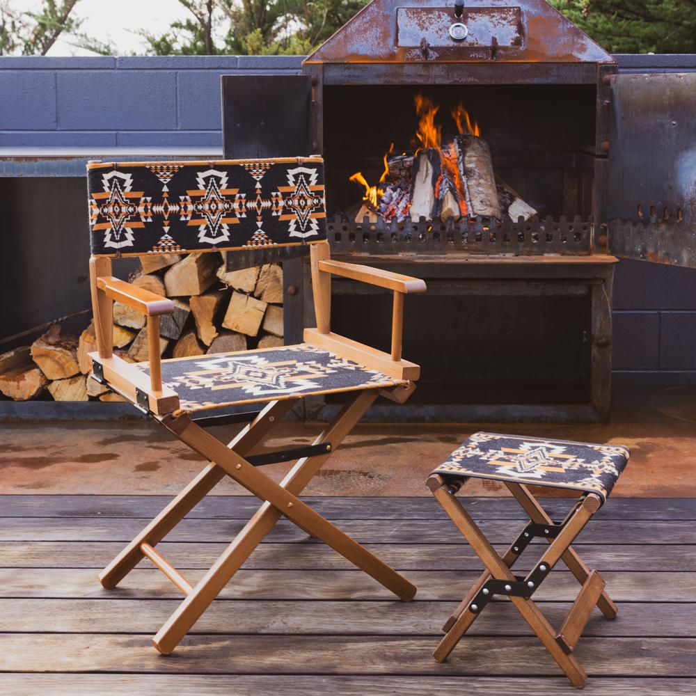 Anifurry Mohave director chair with patterned cushions and a stool in front of a fire pit.