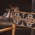 Anifurry Mohave Director Chair with a patterned backrest in front of a fire