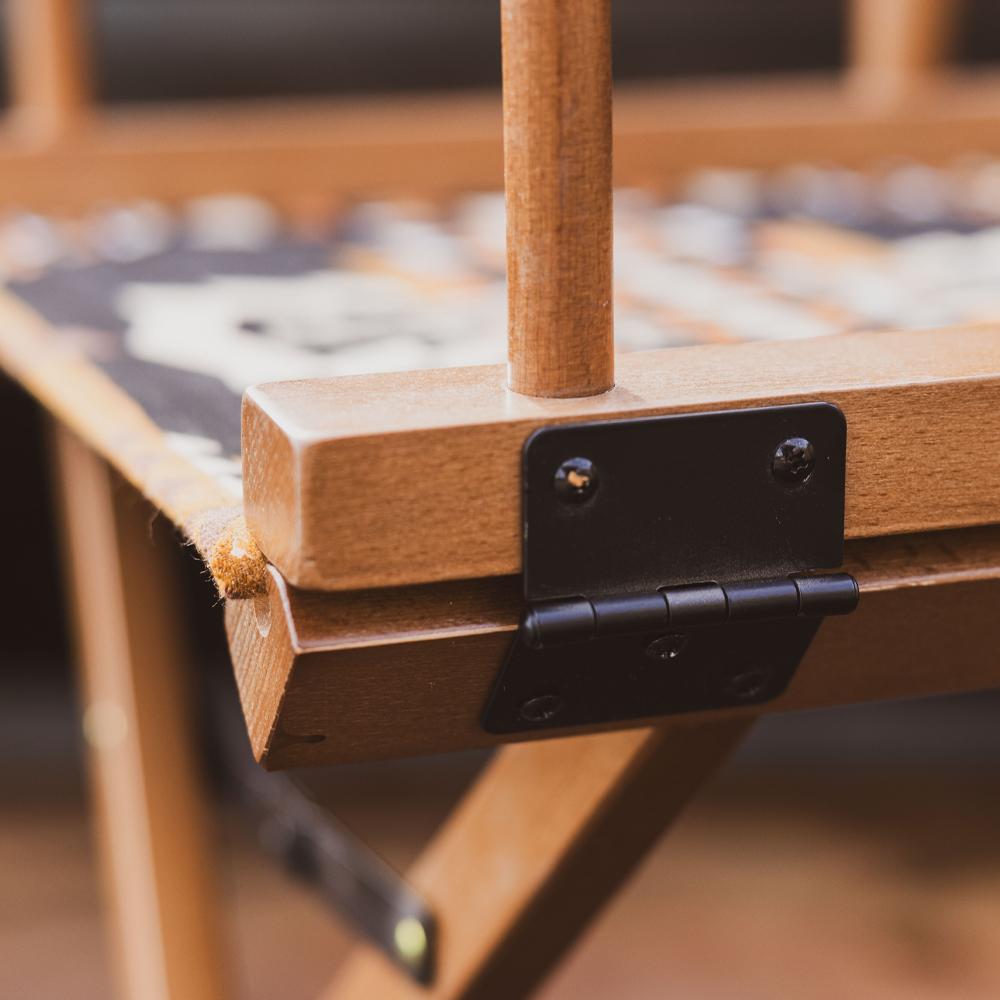 Close-up of a Mohave Director Chair with a black metal hinge
