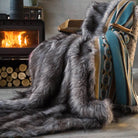 The gray long pile blanket draped over the chair next to the fireplace is suitable for decorating chairs and winter living rooms, and is also very warm.