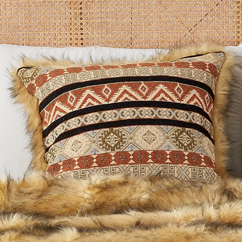 Golden faux fur & Ocher Kilim style pillow cover on a bed with a same color faux fur blanket.