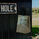 Outdoor picnic tote bag with 'ANIFURRY' branding hanging on a black door 