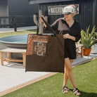 A woman holding a large brown outdoor picnic tote with an Anifurry logo in an outdoor setting