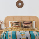 Ruby Kilim Faux Fur Pillow Cover and Turquoise aztec grey faux fur blanket on the bed.