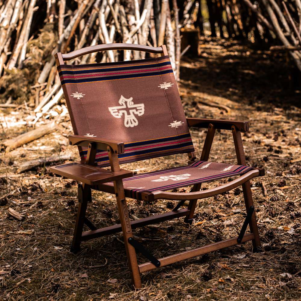 Anifurry wood camping chair with a thunderbird-patterned fabric in a forest setting, featuring a hanging tray on the side.