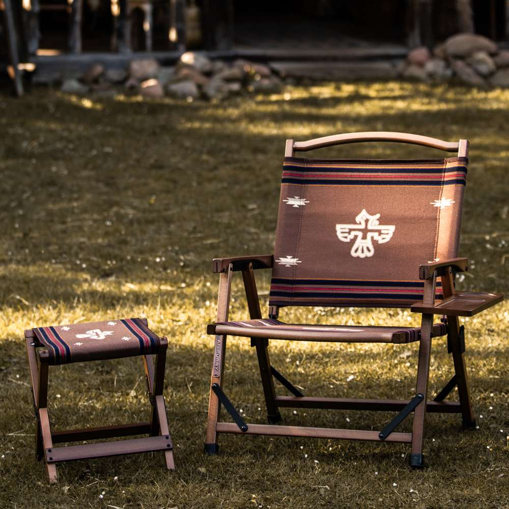 Anifurry wood camping chair and stool with a thunderbird-patterned design on a grassy area.